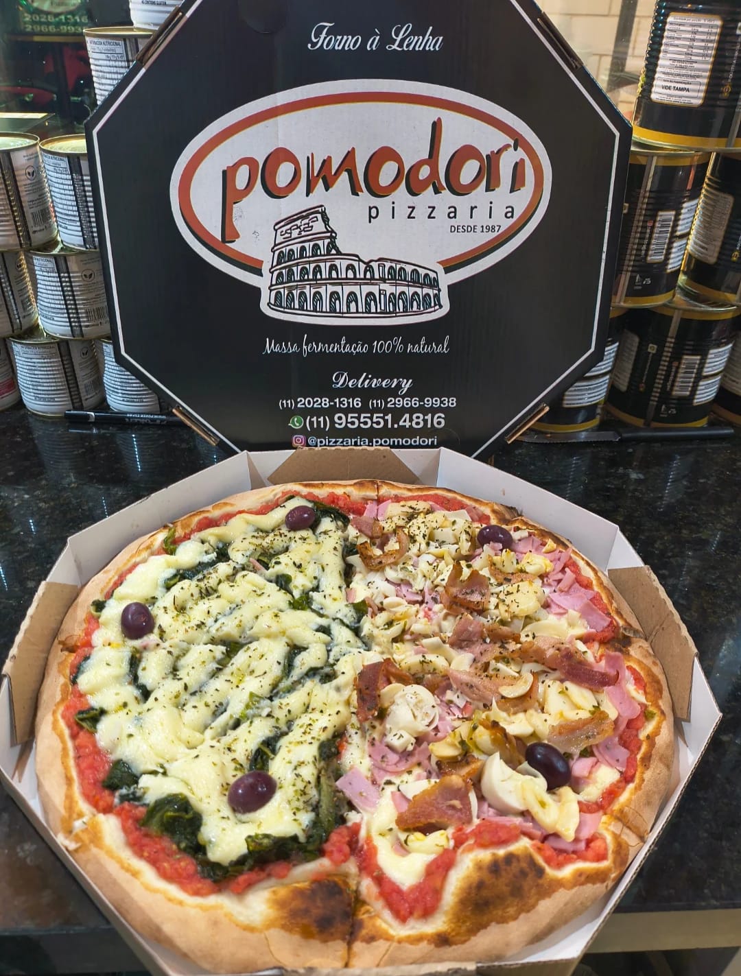 Pizza meio a meio: escarola com mussarela de um lado e Pomodori — presunto, bacon, champignon, palmito e catupiry — do outro